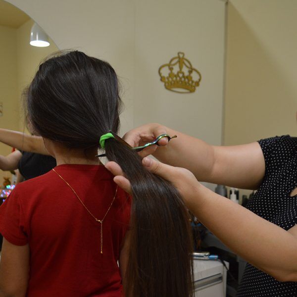 Menina doa cabelo para crianças com câncer