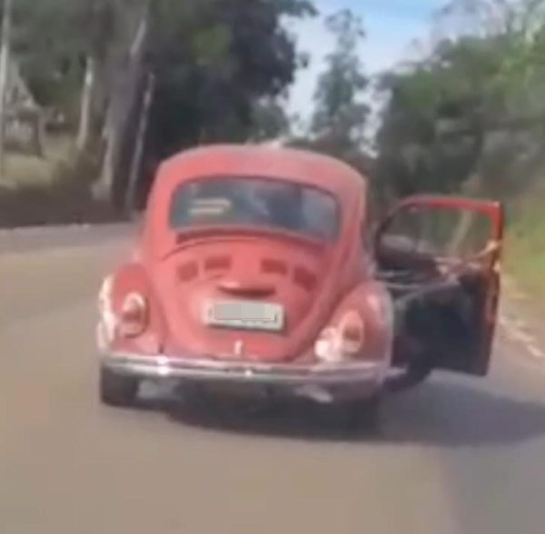 Motorista transporta moto em Fusca com a porta aberta