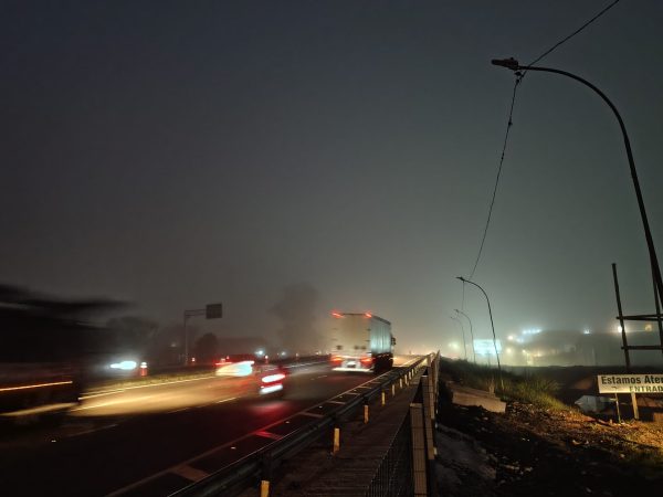 Uma rodovia escura, com neblina e pouca visibilidade